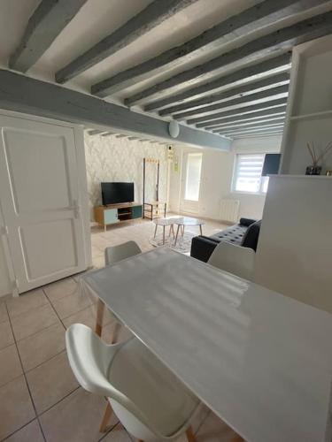 un salon avec une table et des chaises blanches dans l'établissement La Symphorine, à Grandvilliers