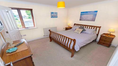 a bedroom with a bed and a desk with two lamps at Oyster Cottage Braunton | Sleeps 6 | Dog Friendly in Braunton