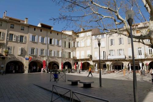a street with buildings and benches in a plaza at Joli studio en plein centre ville - Nyons in Nyons