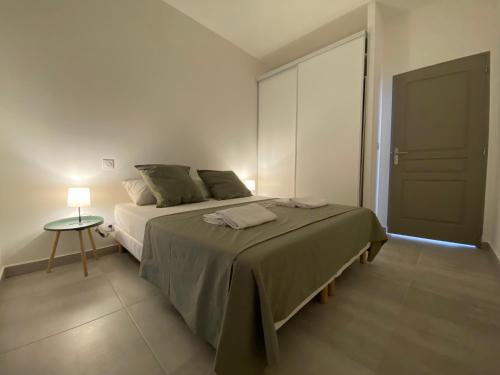 1 dormitorio con 1 cama y 1 mesa con lámpara en Le petit prince en Balaruc-les-Bains