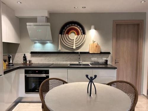 a white kitchen with a table and chairs at O live Kalamata in Kalamata