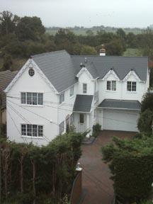 a large white house with a gray roof at Waratah Lodge in South Hayling