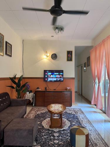 Perdana Cottage, Peaceful & Cozy Residential Area في سونغاي بيتاني: غرفة معيشة مع أريكة وطاولة
