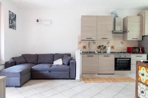 ein Wohnzimmer mit einem Sofa und einer Küche in der Unterkunft Appartamento Giulia in Besnate