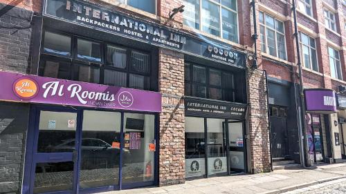 una tienda con una señal púrpura en un lado de un edificio en International Inn en Liverpool