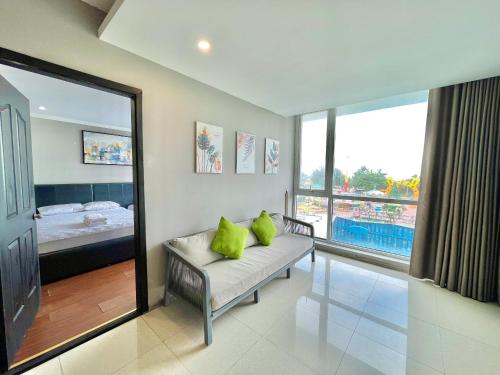 Una habitación con un sofá con dos almohadas verdes encima. en Nice Oasky Vung Tau Apartment 88, en Vung Tau