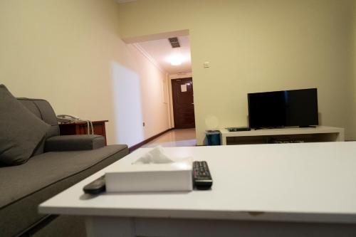 a living room with a couch and a tv at Majestic Hotel in Manama