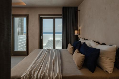 a bedroom with a large bed with a view of the ocean at Naxos Rhyton in Naxos Chora