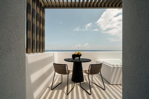 a table and chairs on a balcony with a view of the ocean at Naxos Rhyton in Naxos Chora