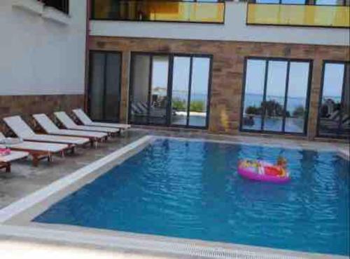 a large swimming pool with a pink raft in a building at Luxury Apartments Golden Residence 3 in Sarandë