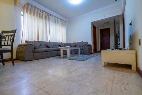 a living room with a couch and a tv at Majestic Hotel in Manama