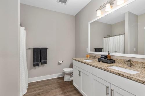 Baño con 2 lavabos y espejo en Modern 2BR 2BA New Build Condo with Garage & Patio en Wyoming