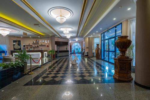 a lobby with a checkered floor in a building at Majestic Hotel in Manama
