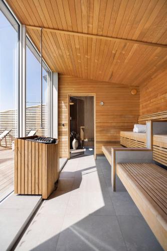 a bedroom with wooden walls and a large window at Ringenäs Hotell & Konferens in Halmstad