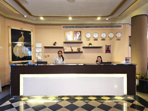 two women sitting at a counter in a restaurant at Majestic Hotel in Manama