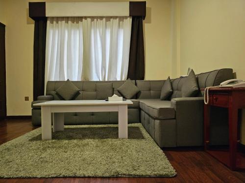 a living room with a couch and a table at Majestic Hotel in Manama