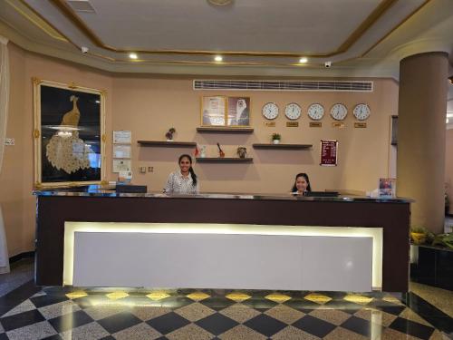 two women sitting at a counter in a waiting room at Majestic Hotel in Manama