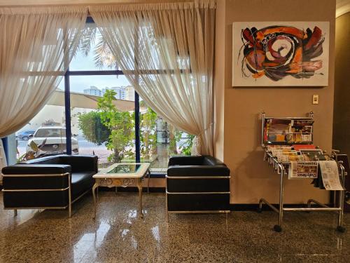 a living room with two chairs and a table and a window at Majestic Hotel in Manama
