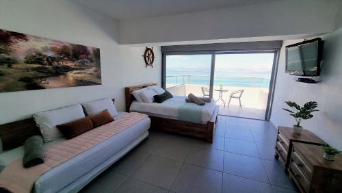 a bedroom with a bed and a couch and a balcony at Galilee Triple Terrace in Tiberias