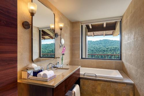 ダラムシャーラーにあるStorii By ITC Hotels, Amoha Retreat Dharamshalaのバスルーム(バスタブ、シンク付)、窓が備わります。