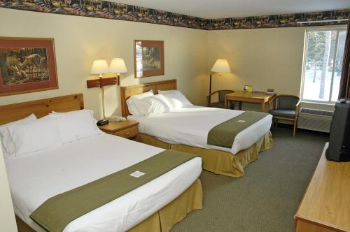 A bed or beds in a room at Pellston Lodge