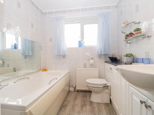 a white bathroom with a tub and a sink and a toilet at Melita in Langport