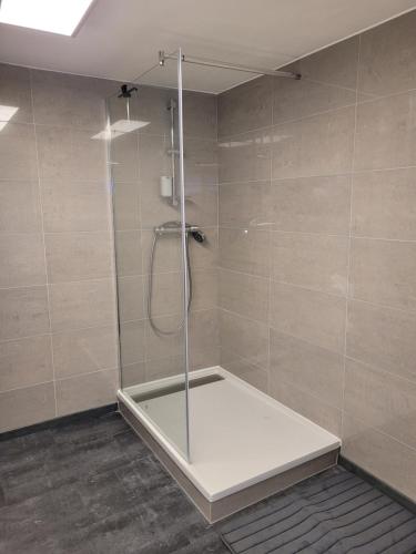 a shower with a glass door in a bathroom at Haus Lärche - Die Ferienwohnung in Wolfratshausen