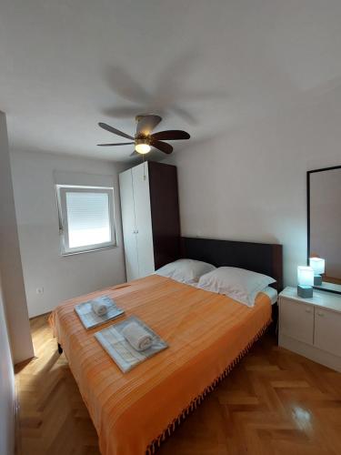 a bedroom with a large bed with a ceiling fan at MAholiday in Makarska