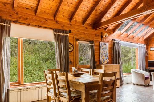 jadalnia ze stołem, krzesłami i oknami w obiekcie BOG Melania - casa en el bosque w mieście Villa La Angostura
