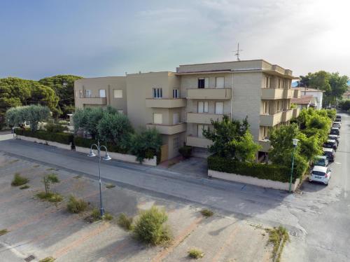 an apartment building on a street with a parking lot at Hotel Quisisana in Vada