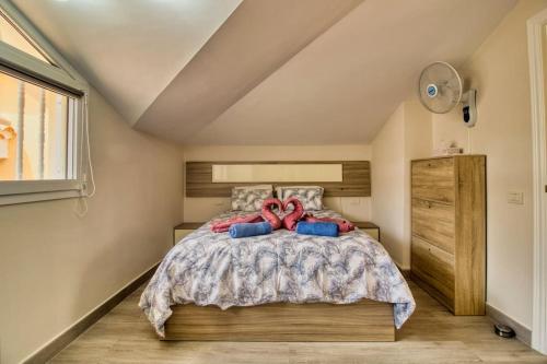 een slaapkamer met een bed met twee rode handvatten bij Duplex Paradise Parque Tropical 1 Los Cristianos in Los Cristianos