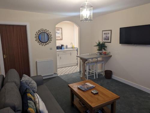 a living room with a couch and a table at Idyllic, Luxurious Seaside Flat for 4. in Borth