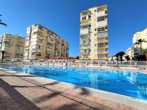 una piscina con due edifici alti sullo sfondo di A&C Algarrobo costa - Malaga a Algarrobo-Costa