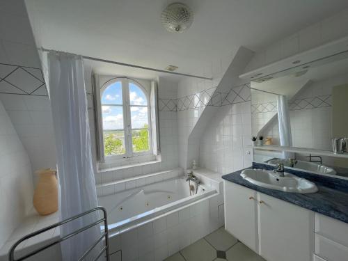 biała łazienka z wanną i umywalką w obiekcie Le Jardin Umal w mieście Montendre