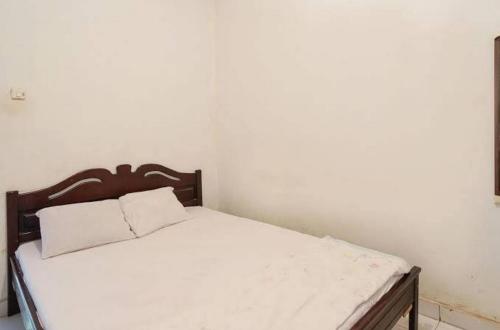 a bed with a wooden headboard in a room at Mountain View Homestay in Tomohon