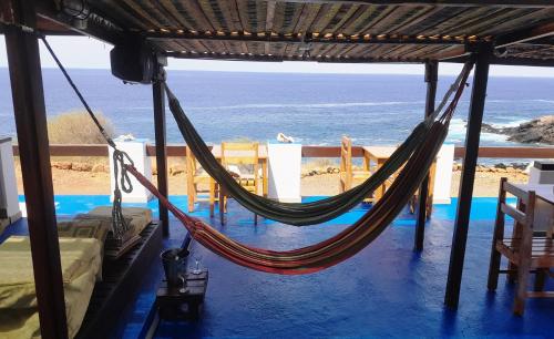 a hammock in a room with a view of the ocean at Pousada Villa Concetta in Cidade Velha