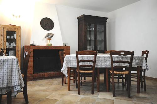 una sala da pranzo con tavolo, sedie e camino di COUNTRY HOUSE a Sezze