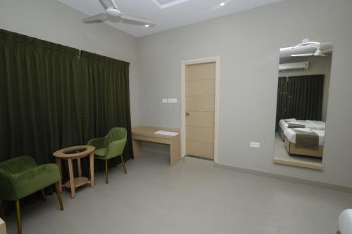 a hospital room with a bed and a table and chairs at Grand Courtyard Business Hotel in Chennai