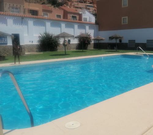 una gran piscina azul en un edificio en Casa Rosita Relax - Piscina y gran terraza, en Aguadulce