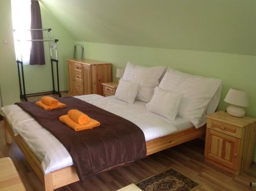 ヘーヴィーズにあるApartment Villa Attilaのベッドルーム1室(ベッド1台、オレンジのタオル2枚付)