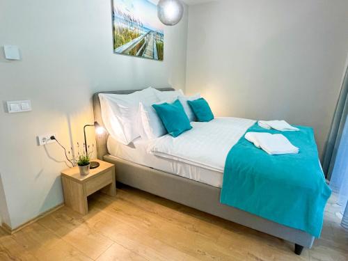 a small bedroom with a bed with blue pillows at Aqua Apartman in Zalakaros