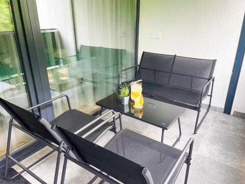 a balcony with two chairs and a table with a plant on it at Aqua Apartman in Zalakaros