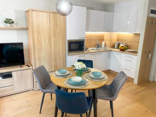 a kitchen with a wooden table with chairs and a dining room at Aqua Apartman in Zalakaros
