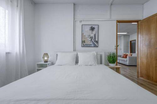 a white bedroom with a large white bed with white sheets at Travel & Live Fernão Magalhães in Porto