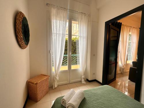 une chambre avec un lit et une grande fenêtre dans l'établissement Appartamento La Grande Bleue, à Menton