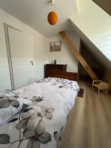 a bedroom with a bed with a floral comforter at Le Cerisier - Route des vins - Parking et terrasse avec vue sur montagnes et vignoble in Sigolsheim