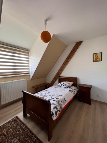 ein Schlafzimmer mit einem Bett im Dachgeschoss in der Unterkunft Le Cerisier - Charmante maison dans le vignoble in Sigolsheim