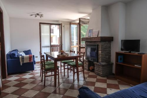 a living room with a table and a fireplace at Villa Luzzago in Ponte di Legno