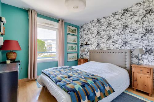 une chambre avec un lit et un mur bleu dans l'établissement Évasion près du port des Sables d'Olonne, à Les Sables-dʼOlonne