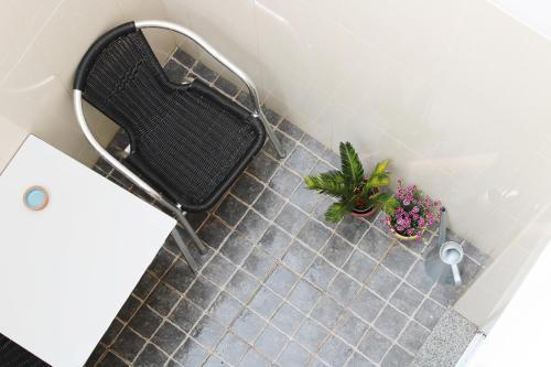 ein Bad mit einem Stuhl und Blumen auf einem Fliesenboden in der Unterkunft Casa da Cal Branca in Évora